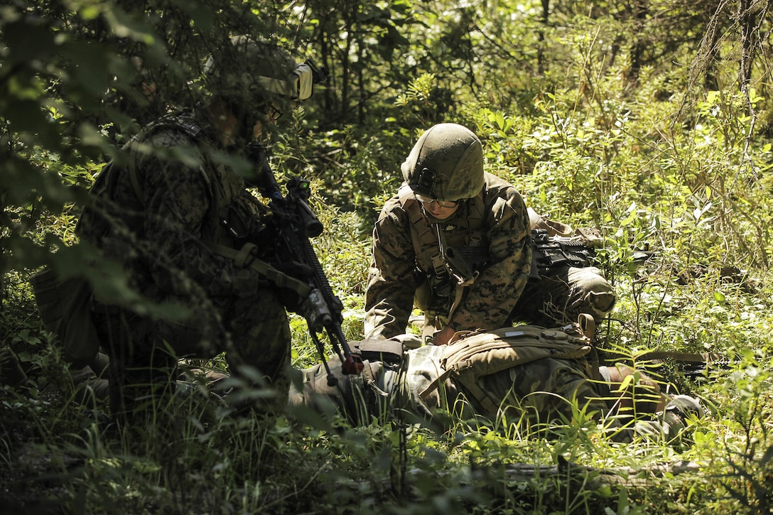 U.S. Marines with Super Squad Competition 1st Squad, out of 1st Battalion, 25th Marine Regiment, 4th Marine Division, Marine Forces Reserve, check defeated oppositional forces for weapons and intel while conducting offensive/defensive field operations on Joint Base Elmendorf-Richardson, Alaska, Aug. 6, 2017.
