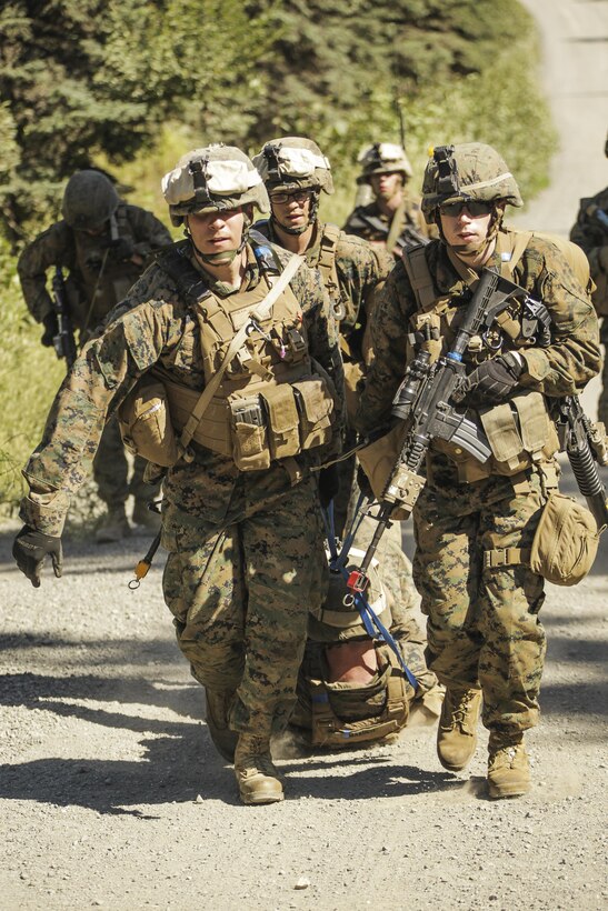 U.S. Marines with Super Squad Competition 1st Squad, out of 1st Battalion, 25th Marine Regiment, 4th Marine Division, Marine Forces Reserve, evacuate their wounded after sustaining simulated casualties while conducting offensive/defensive field operations on Joint Base Elmendorf-Richardson, Alaska, Aug. 6, 2017.