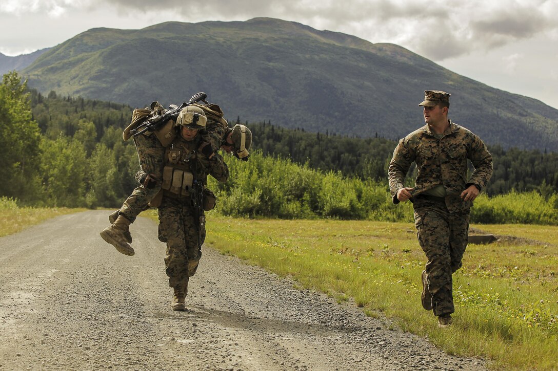 U.S. Marines with 1st Battalion, 25th Marine Regiment, 4th Marine Division, Marine Forces Reserve and members of 1st Squad fireman carry one another while completing a timed grenade assault range during the Combat Marksmanship Endurance Test in the Small Arms Complex on Joint Base Elmendorf-Richardson, Alaska, Aug. 8, 2017.