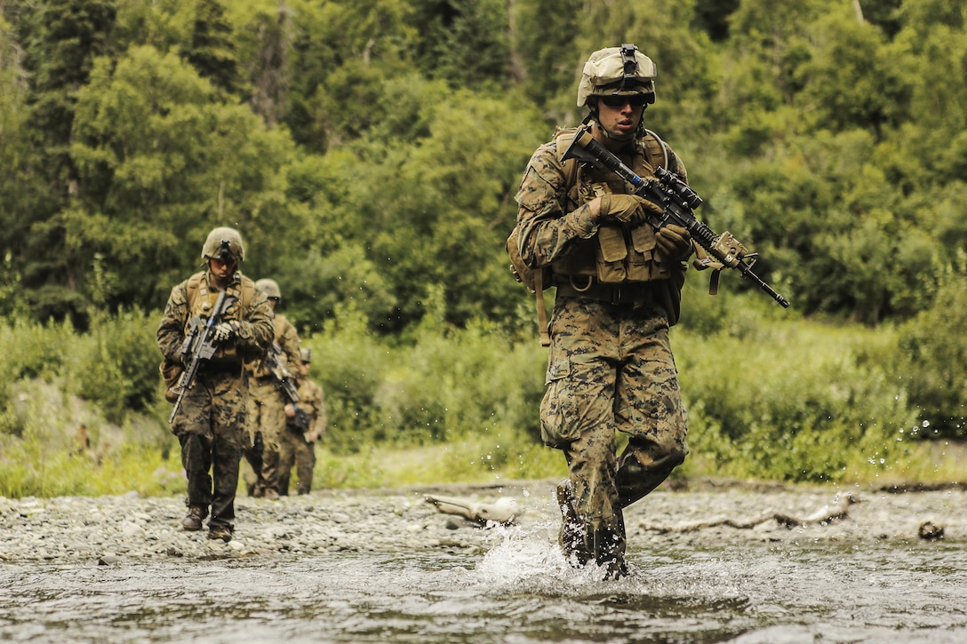 U.S. Marines with Super Squad Competition 1st Squad, out of 1st Battalion, 25th Marine Regiment, 4th Marine Division, Marine Forces Reserve, conduct a river crossing during the Combat Marksmanship Endurance Test Phase II on Joint Base Elmendorf-Richardson, Alaska, Aug. 8, 2017.