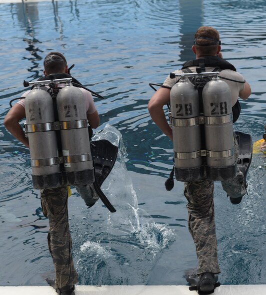 U.S. Air Force diving students step into a pool for a training exercise at Naval Support Activity Panama City, Fla., Aug. 2. 2017. The Naval Diving and Salvage Training Center is the Department of Defense's largest dive school and trains members of all five military branches.