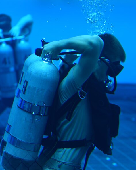 A U.S. Air Force diving student adjusts his air tank during an underwater exercise at Naval Support Activity Panama City, Fla., Aug. 3, 2017. The training involved testing the students on whether they were able to put their diving gear on while already underwater. This would test their ability to operate under emergency situations.