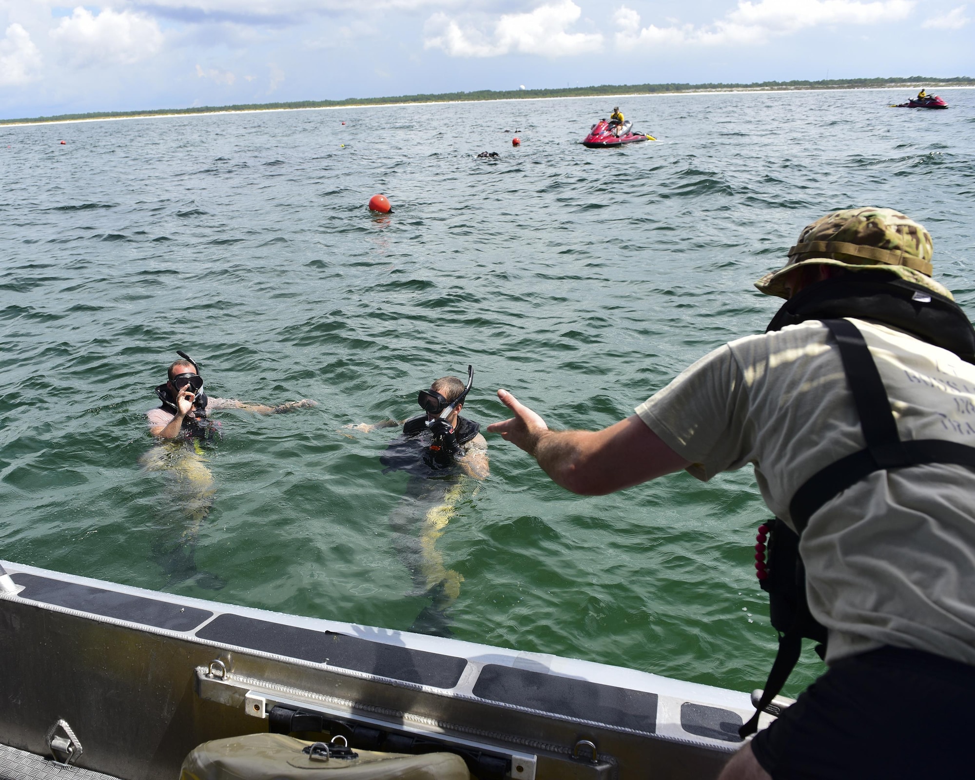 Naval Diving and Salvage Training Center students consult with one another during a training exercise in the Gulf of Mexico, Aug. 15, 2017. Air Force combat rescue officers also go through the same training alongside their enlisted counterparts during this course.