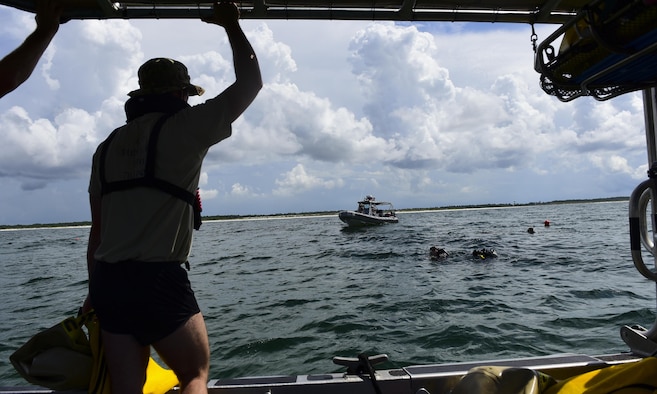 A U.S. Air Force combat rescue officer trainee observes his fellow students during a training exercise in the Gulf of Mexico, Aug. 15, 2017. The Naval Diving and Salvage Training Center in Panama City, Fla., trains more than 1,200 students each year.