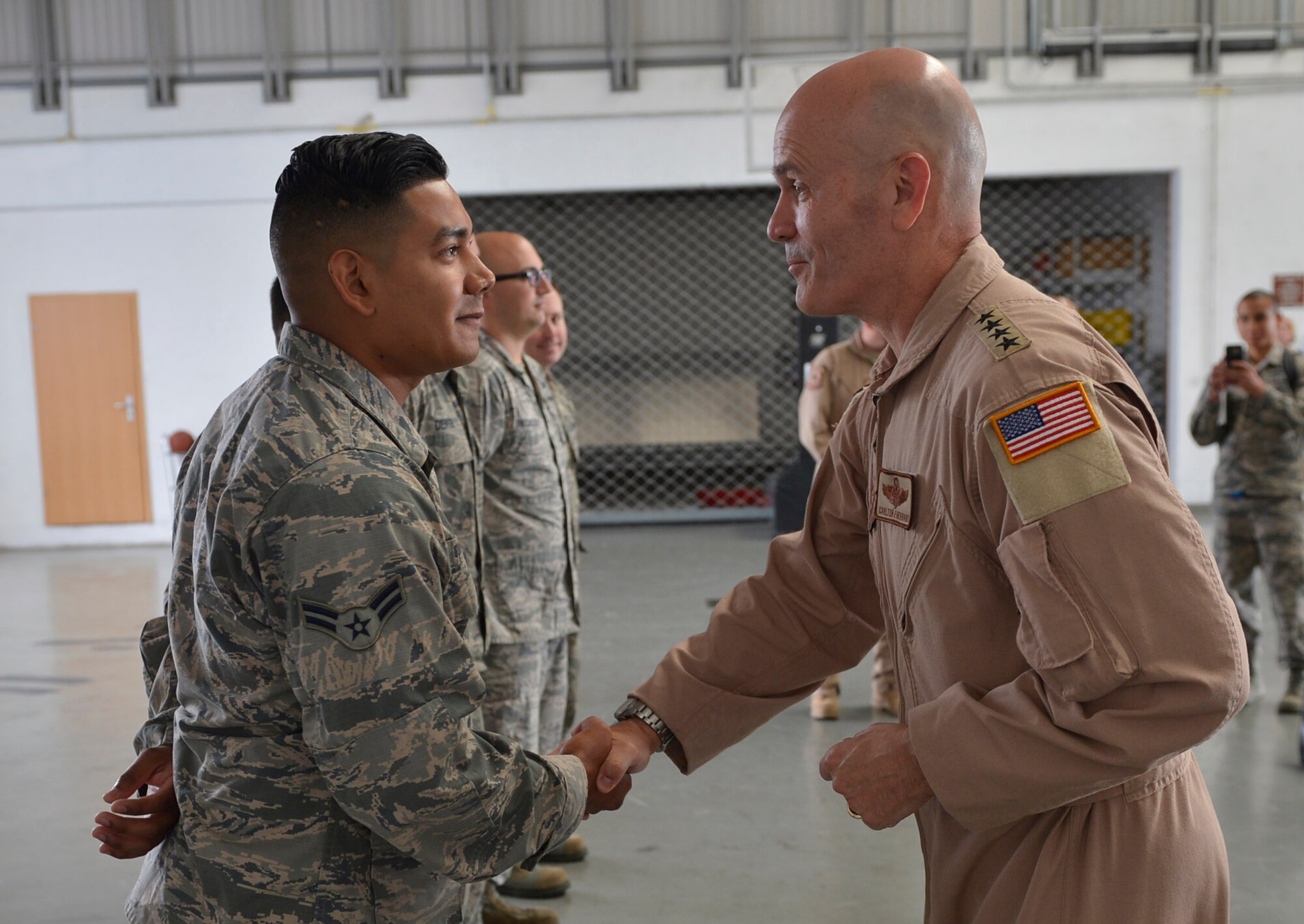General shakes Airman's hand