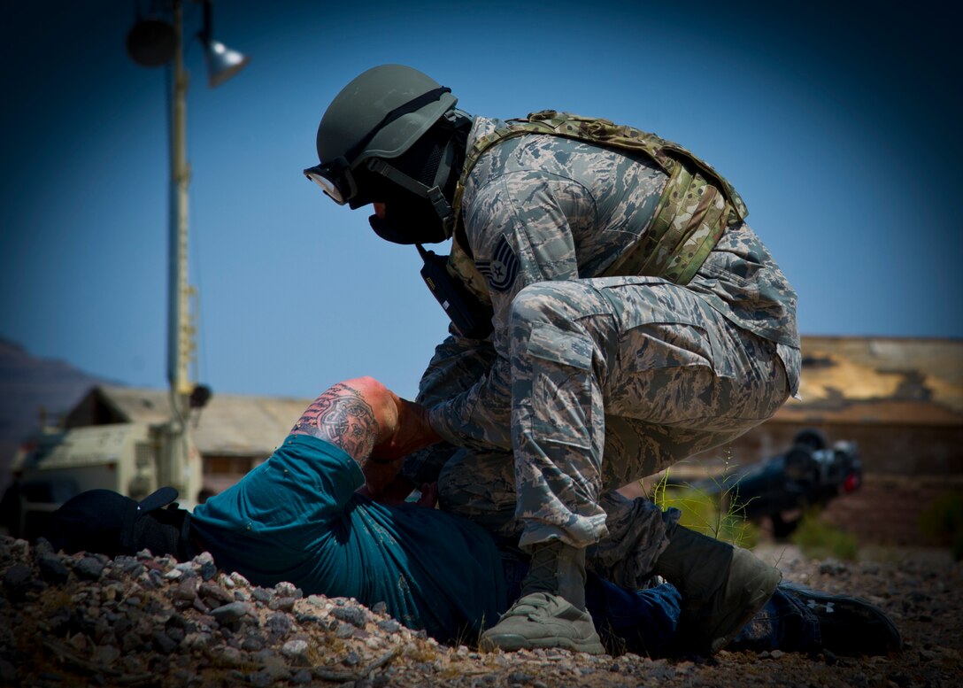 Tech Sgt. Nolan Hamilton, 926th Security Forces Squadron team leader, pats down a mock insurgent and places him into custody at Camp Cobra, August 5, 2017, at Nellis Air Force Base, Nev.