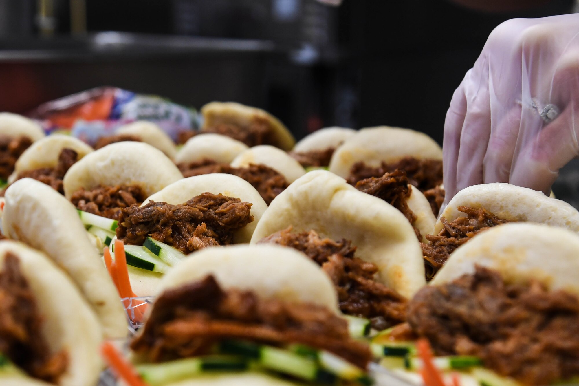 Senior Airman Kimberlyann Crisostomo, 2nd Force Support Squadron guest services representative makes an open face pork bun sandwich during an advanced culinary skills course graduation at the Red River Dining Facility at Barksdale Air Force Base, La., Aug. 18, 2017. Crisostomo, a native of Guam made an island dish to showcase her heritage.