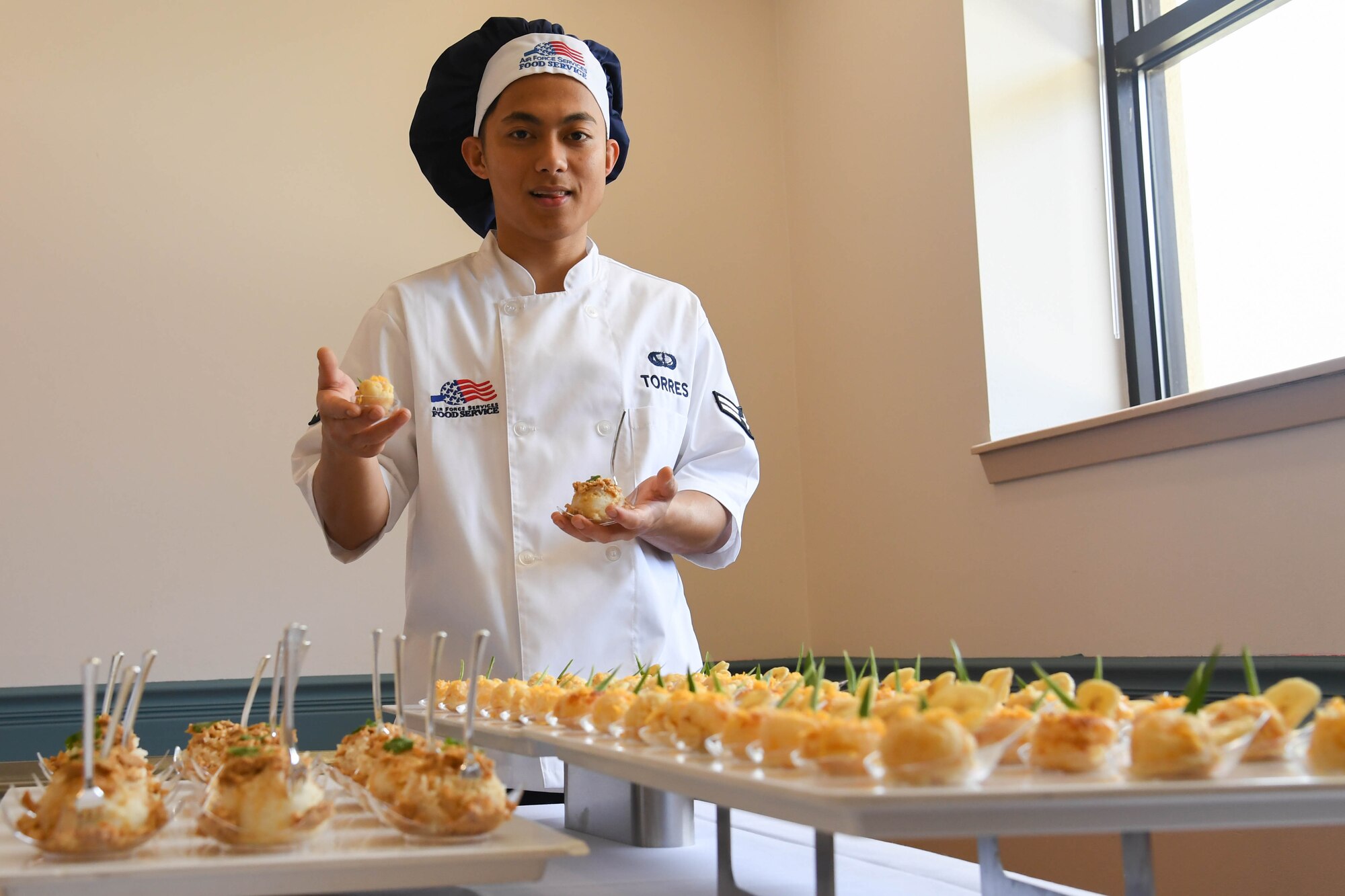 Airman 1st Class Lester Torres, 2nd Force Support Squadron food services apprentice presents his dish during an advanced culinary skills course graduation at the Red River Dining Facility at Barksdale Air Force Base, La., Aug. 18, 2017.Torres’ prepared a cassava cake dessert local to the Philippines.