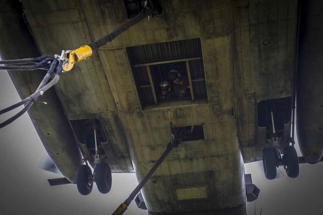 Two crew chiefs assigned to Marine Heavy Helicopter Squadron 462 look outside of a CH-53E Super Stallion during external lift training at Draughon Range near Misawa Air Base, Japan, August 21, 2017, in support of exercise Northern Viper 17. This combined-joint exercise is held to enhance regional cooperation between participating nations to collectively deter security threats. The crew chiefs are assigned to HMH-462, Marine Aircraft Group 16, 3rd Marine Aircraft Wing, currently forward deployed under the Unit Deployment Program with Marine Aircraft Group 36, 1st MAW, based out of Okinawa, Japan.  (U.S. Marine Corps photo by Lance Cpl. Andy Martinez)