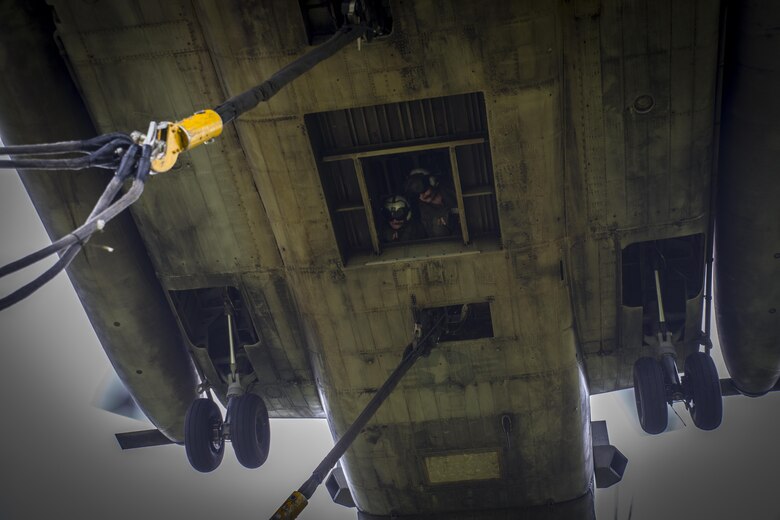 Two crew chiefs assigned to Marine Heavy Helicopter Squadron 462 look outside of a CH-53E Super Stallion during external lift training at Draughon Range near Misawa Air Base, Japan, August 21, 2017, in support of exercise Northern Viper 17.