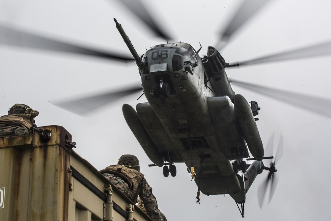 A CH-53E Super Stallion assigned to Marine Heavy Helicopter Squadron 462 hovers above a landing support specialist Marine waiting to hook a container to the helicopter during external lift training at Draughon Range near Misawa Air Base, Japan, August 21, 2017, in support of exercise Northern Viper 17. This combined-joint exercise is held to enhance regional cooperation between participating nations to collectively deter security threats. The aircraft is assigned to HMH-462, Marine Aircraft Group 16, 3rd Marine Aircraft Wing, currently forward deployed under the Unit Deployment Program with Marine Aircraft Group 36, 1st MAW, based out of Okinawa, Japan.  (U.S. Marine Corps photo by Lance Cpl. Andy Martinez)