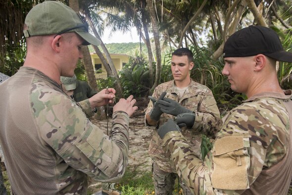 U.S. Air Force Tech. Sgt. Ryan Hyslop, Air Force Global Strike Command Det. 4 survival, evasion, resistance and escape specialist, left, teaches U.S. Air Force Senior Airman Tyler Lewellen, AFGSC Det. 4 aerospace ground equipment journeyman, middle, and U.S. Air Force Staff. Sgt. Bryce Weaver, AFGSC Det. 4 unit training manager, right, how to properly tie a knot July 27, 2017, at Andersen Air Force Base, Guam. The SERE course taught jungle-specific survival techniques to individuals at risk of being isolated in a jungle environment.  (U.S. Air Force photo by Airman 1st Class Christopher Quail)