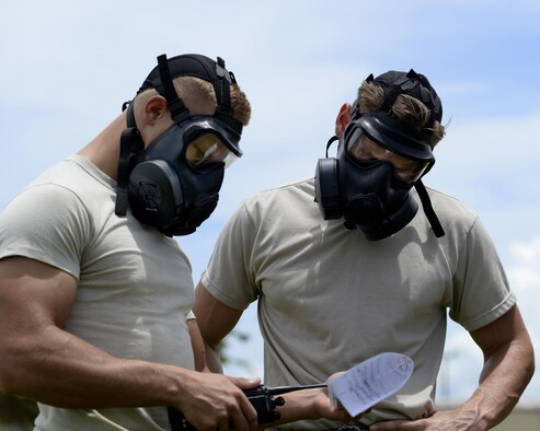 Airman 1st Class Joshua Hawn, left, and Senior Airman Zachary Downing, right, 36th Civil Engineer Squadron pavements and equipment operators, practice operating a radio Aug. 17, 2017, at Andersen Air Force Base, Guam. Airmen that participated in the Prime BEEF (Base Engineer Emergency Force) Day practiced accomplishing tasks while in Mission-Oriented Protective Posture (MOPP) gear.  (U.S. Air Force photo/Airman 1st Class Gerald R. Willis)