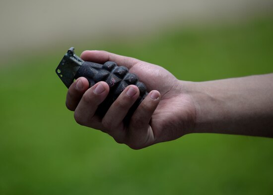 An Airman assigned to the 36th Civil Engineer Squadron holds a training grenade during a training exercise Aug 17, 2017, at Andersen Air Force Base, Guam. This training, known as Prime BEEF (Base Engineer Emergency Force) Day, allowed Airmen to train in dealing with various unexploded ordinances safely in a controlled training environment. (U.S. Air Force photo/Airman 1st Class Gerald R. Willis)