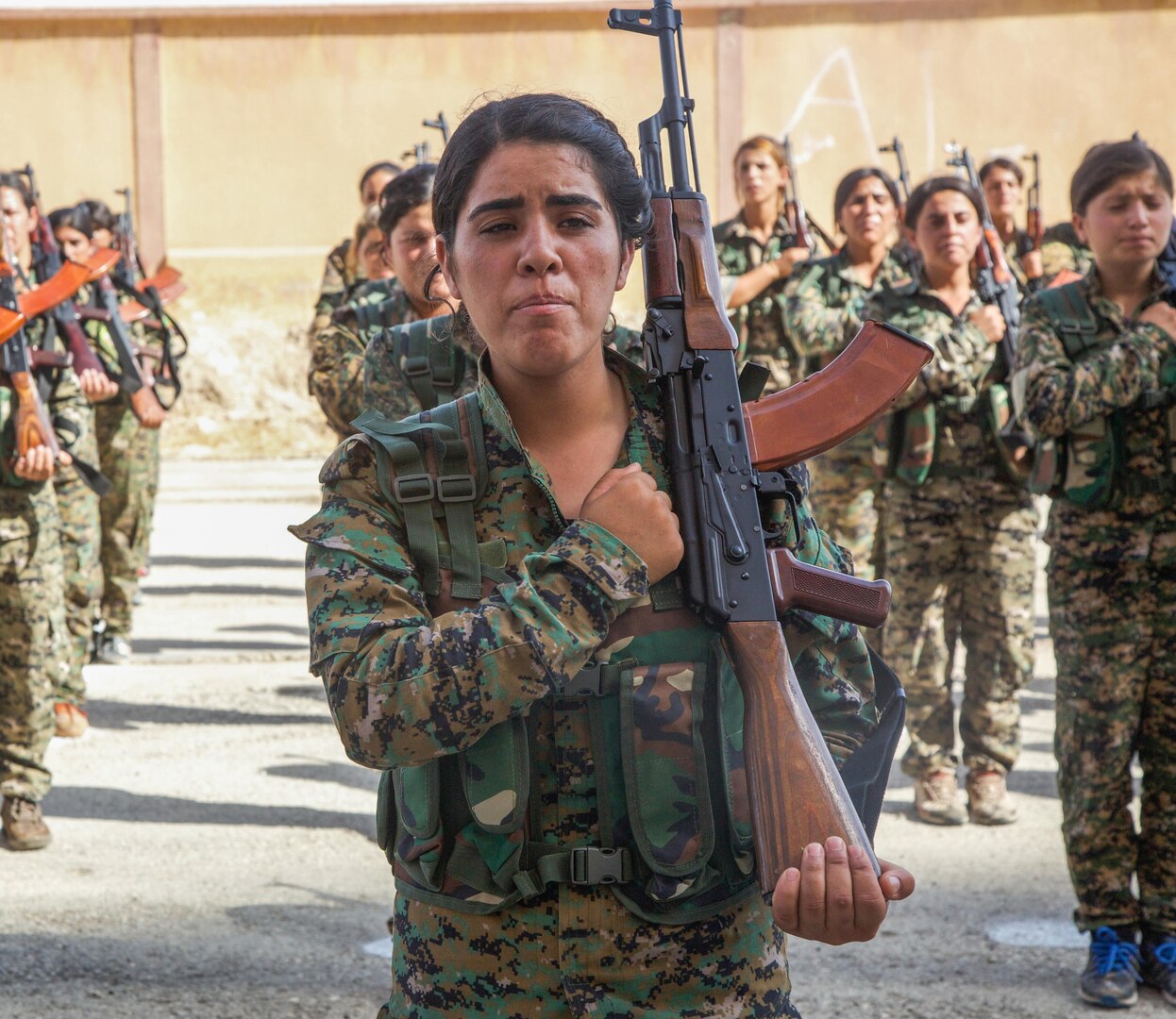 Syrian Democratic Forces trainees, representing an equal amount of Arab and Kurdish volunteers, stand in formation.