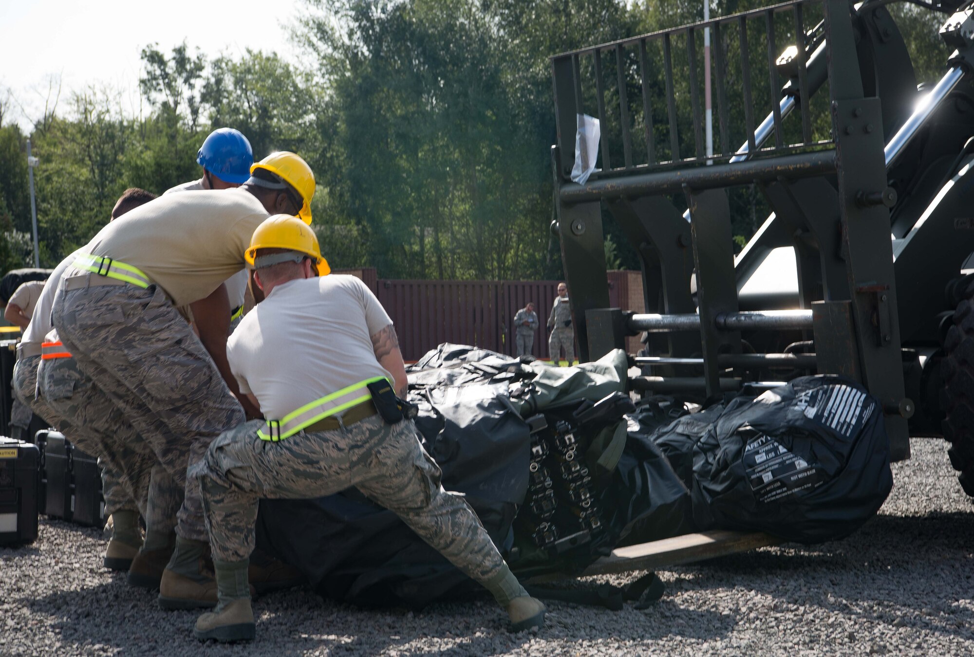 U.S. Airmen assigned to the 1st Combat Communications Squadron offload a communications tent from a fork lift during Exercise Lending Hand on Ramstein Air Base, Germany, Aug. 21, 2017.