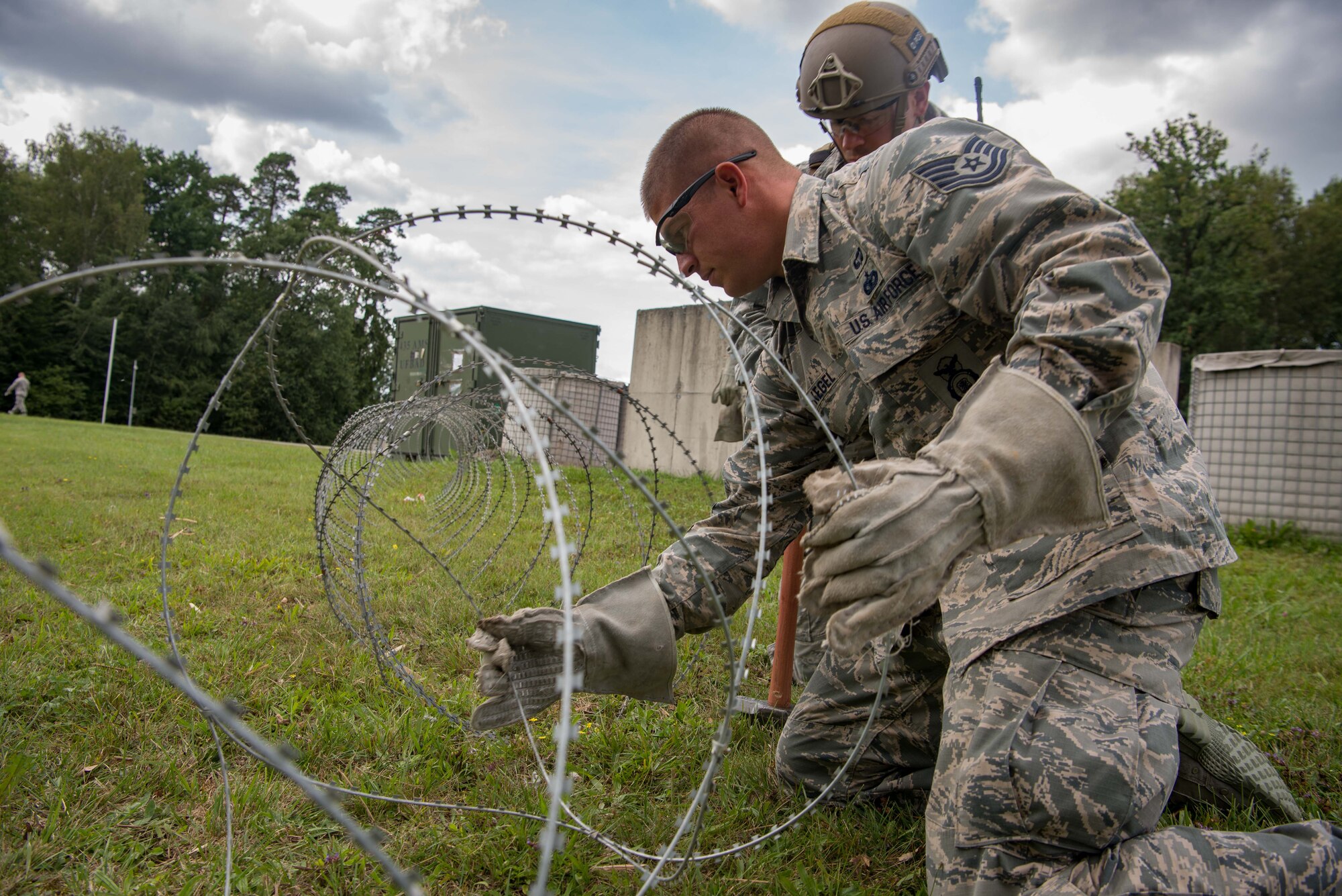 U.S. Air Force Tech. Sgt. Mark Kegel, 435th Security Forces Squadron Phoenix Fist team leader, lays barbed wire around the perimeter of a simulated base during Exercise Lending Hand on Ramstein Air Base, Germany, Aug. 21, 2017.