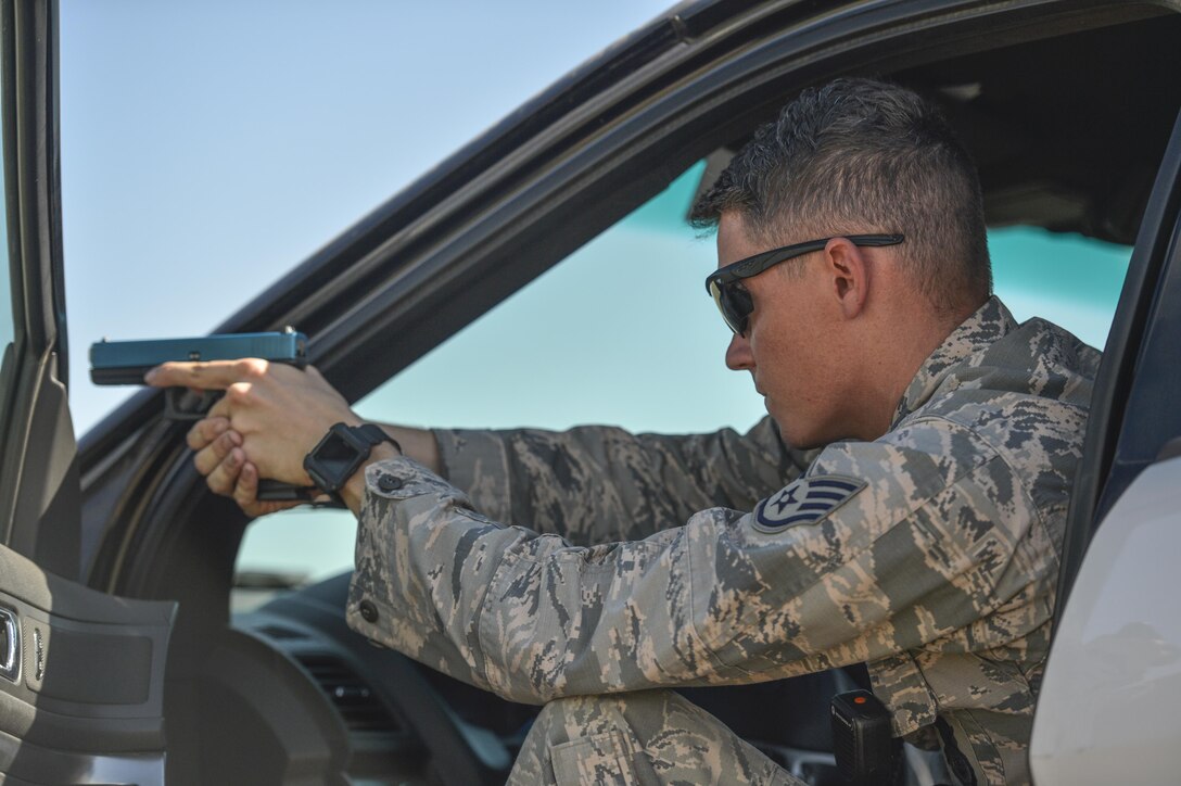 Staff Sgt. Ryan Kneafsey, 56th Security Forces Squadron unit trainer, assists with the apprehension of a suspect arrest during an exercise as part of an Emergency Vehicle Operations Course held at Luke Air Force Base, Ariz., Aug. 21, 2017. Kneafsey and several other 56 SFS members participated in different segments of vehicle backing, braking, pursuit driving and high-risk stops. (U.S. Air Force photo/Airman 1st Class Caleb Worpel)