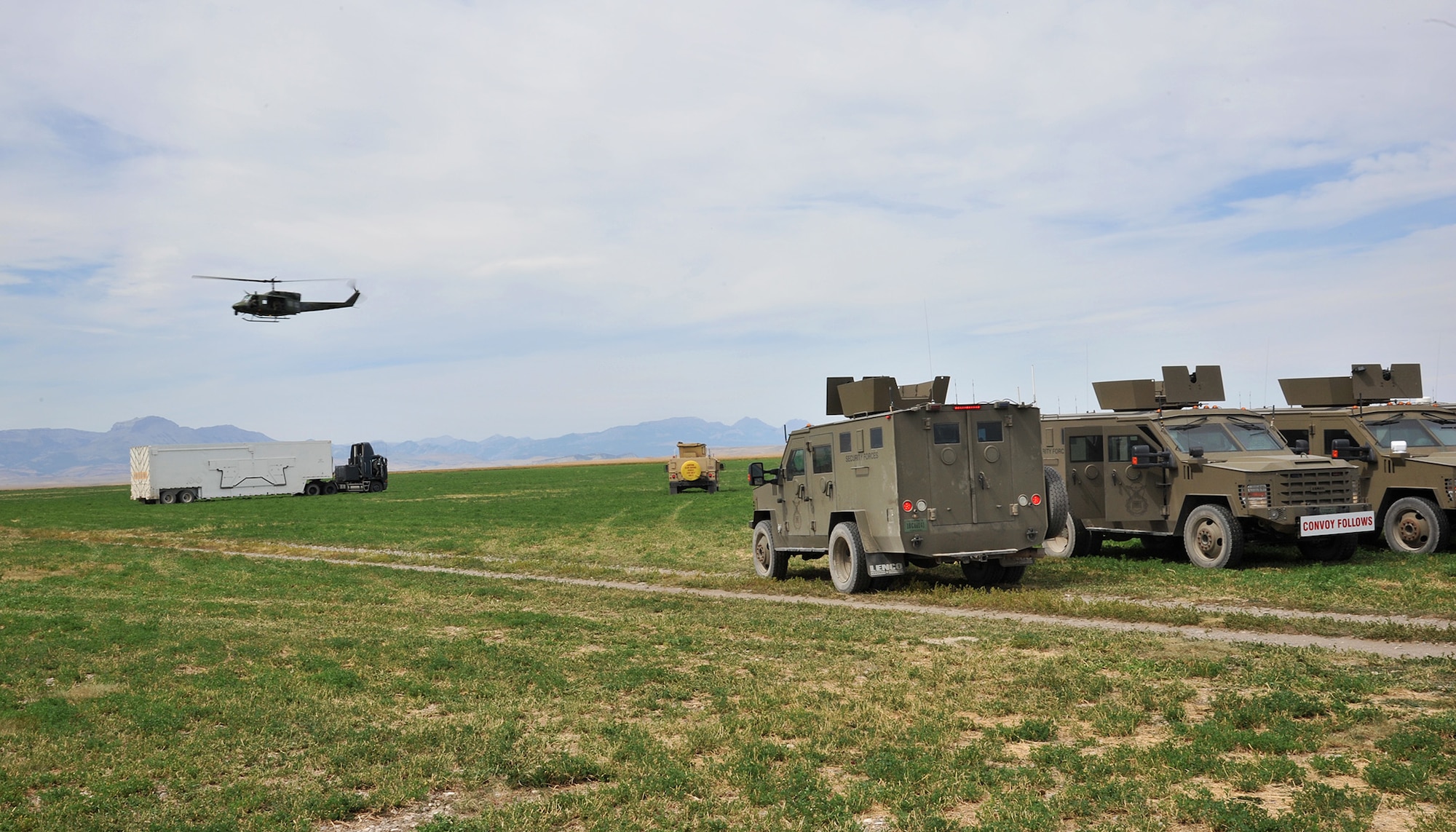 A UH-1N Iroquois helicopter from the 40th Helicopter Squadron circles over a payload transporter and security forces vehicles assigned to the 341st Missile Wing prior to the start of the Local Integrated Response Plan exercise Aug. 16, 2017, near Choteau, Mont.