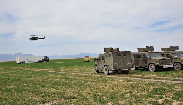 A UH-1N Iroquois helicopter from the 40th Helicopter Squadron circles over a payload transporter and security forces vehicles assigned to the 341st Missile Wing prior to the start of the Local Integrated Response Plan exercise Aug. 16, 2017, near Choteau, Mont.
