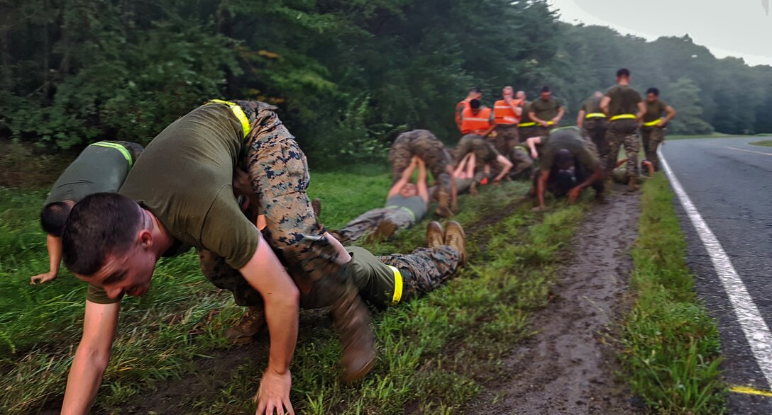 Marine Corps noncommissioned officers literally drag each other through the mud in a pistol drag exercise.