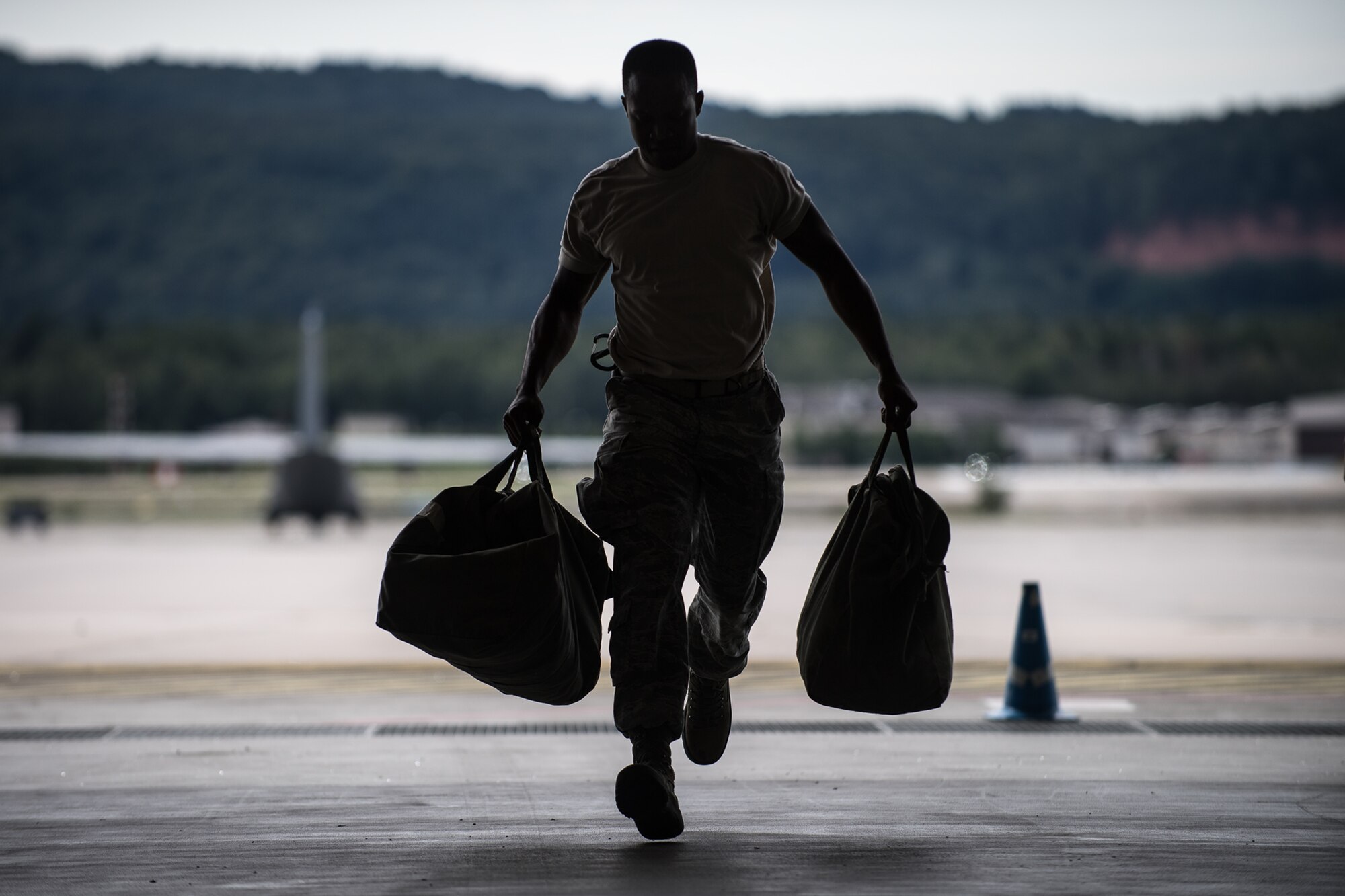 U.S. Air Force Staff Sgt. Kenneth Welch, 86th Aircraft Maintenance Squadron communications countermeasures navigation systems craftsman, runs with equipment bags during a relay race at the Maintainer Olympics in the dual hangar bay on Ramstein Air Base, Germany, Aug. 24, 2017.