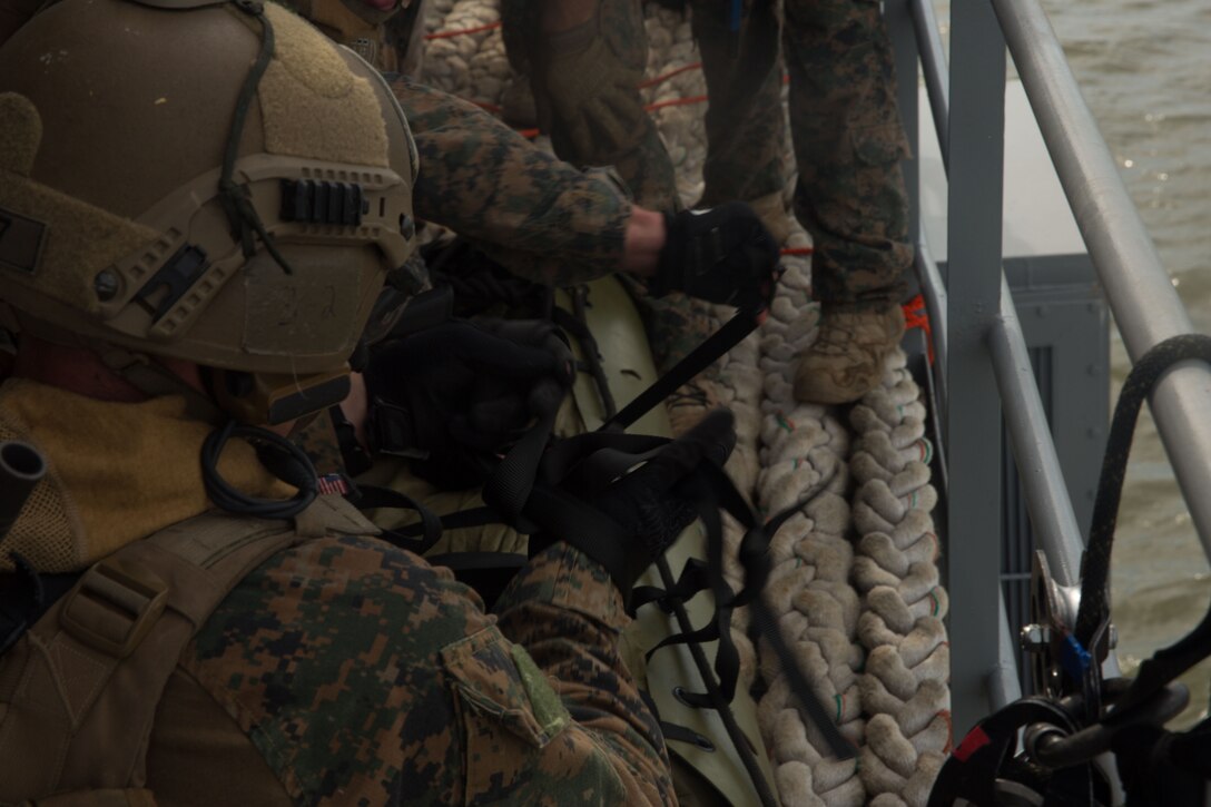 U.S. Marines with the Maritime Raid Force (MRF), 26th Marine Expeditionary Unit (MEU), tie a bowline knot around a simulated casualty during a raid as part of visit, board, search and seizure (VBSS) training at Fort Eustis, Va., Aug. 2, 2017.