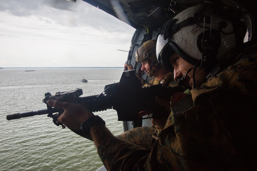 U.S. Marines with the Maritime Raid Force (MRF), 26th Marine Expeditionary Unit (MEU), provide overhead security with a training M4A1 rifle during a raid as part of visit, board, search and seizure (VBSS) training at Fort Eustis, Va., Aug. 2, 2017.