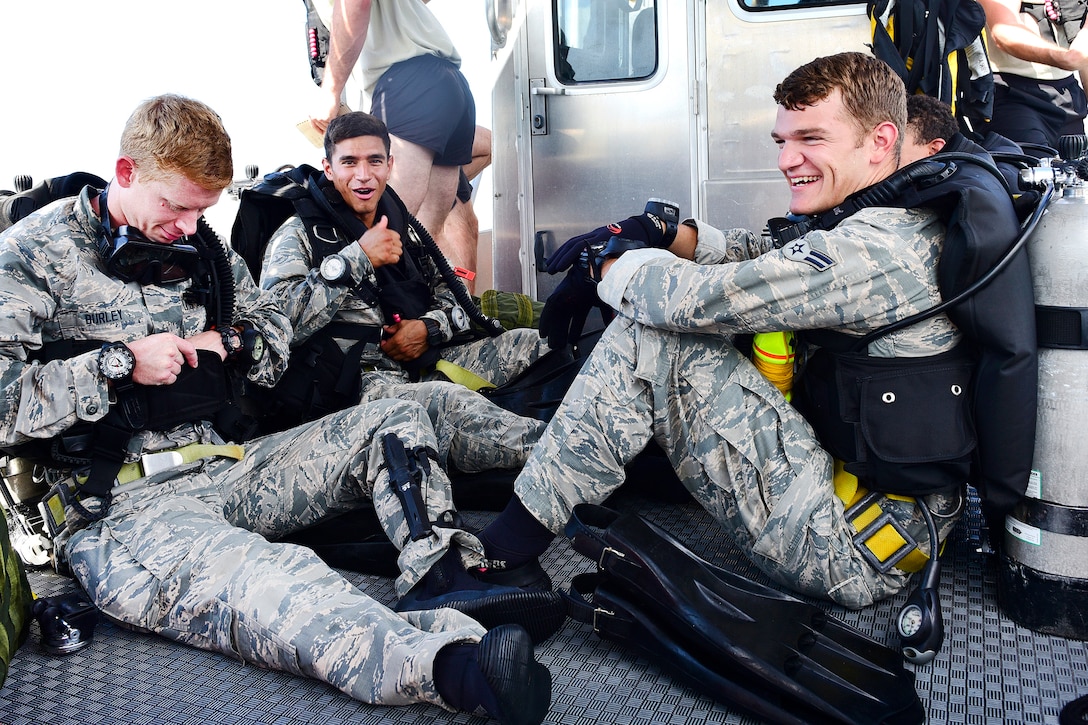 Air Force diving students sit and talk on a boat.