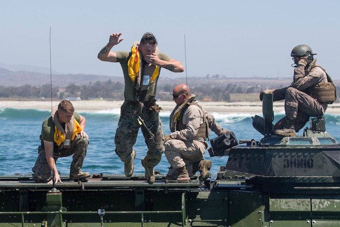A U.S. Marine with 3rd Assault Amphibian Battalion, jumps off an Amphibious Assault Vehicle (AAV) during an annual surf qualification at Camp Pendleton, Calif., Aug. 17, 2017. The annual training included a 500 meter swim from Amphibious Assualt Vehicles (AAV)  to shore to simulate an AAV sinking in the ocean. (U.S. Marine Corps photo by Lance Cpl. Roxanna Gonzalez)