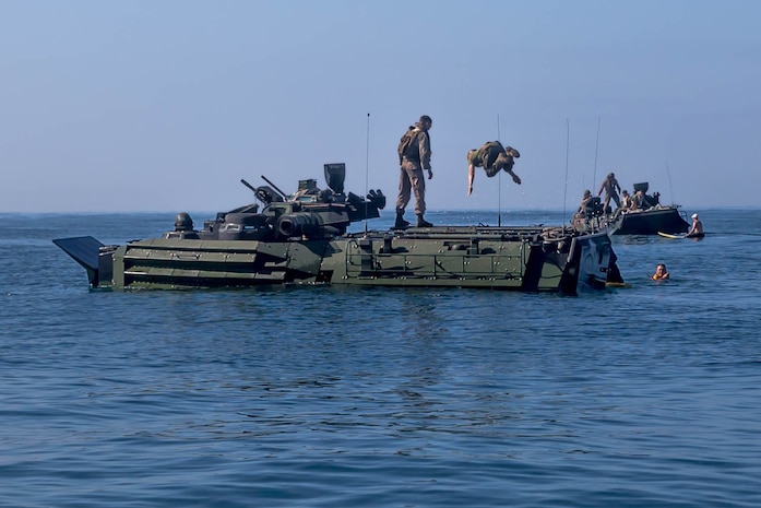A U.S. Marine with 3rd Assault Amphibian Battalion, jumps from an Amphibious Assault Vehicle (AAV) during an annual surf qualification at Camp Pendleton, Calif., Aug. 17, 2017. The annual training included a 500 meter swim from AAVs to shore to simulate an AAV sinking in the ocean. (U.S. Marine Corps photo by Lance Cpl. Roxanna Gonzalez)