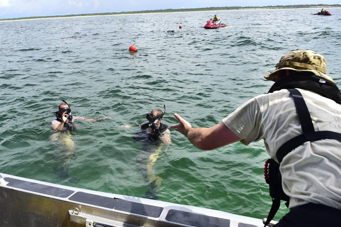 Air Force diving students consult with one another during a recovery training exercise