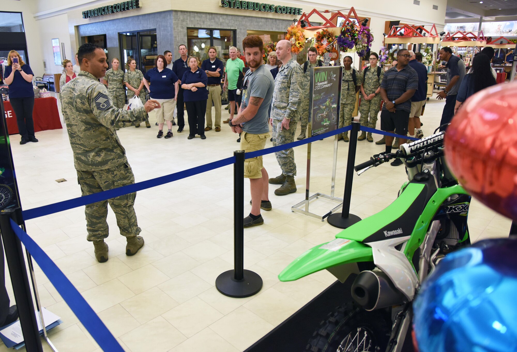 Chief Master Sgt. Luis Reyes, Army & Air Force Exchange Service senior enlisted advisor, Dallas, Texas, presents U.S. Army Spc. Anthony Clark, Alpha Company 1-155th infantryman, Mississippi National Guard, Biloxi, Miss., with a Kawasaki KXTM250F motorcycle at the Base Exchange, Aug. 19, 2017, on Keesler Air Force Base, Miss. Clark, a Biloxi native, was randomly selected from more than 16,000 entries to win the AAFES Monster Kawasaki Sweepstakes, which ran from April 15 to May 31. (U.S. Air Force photo by Kemberly Groue)