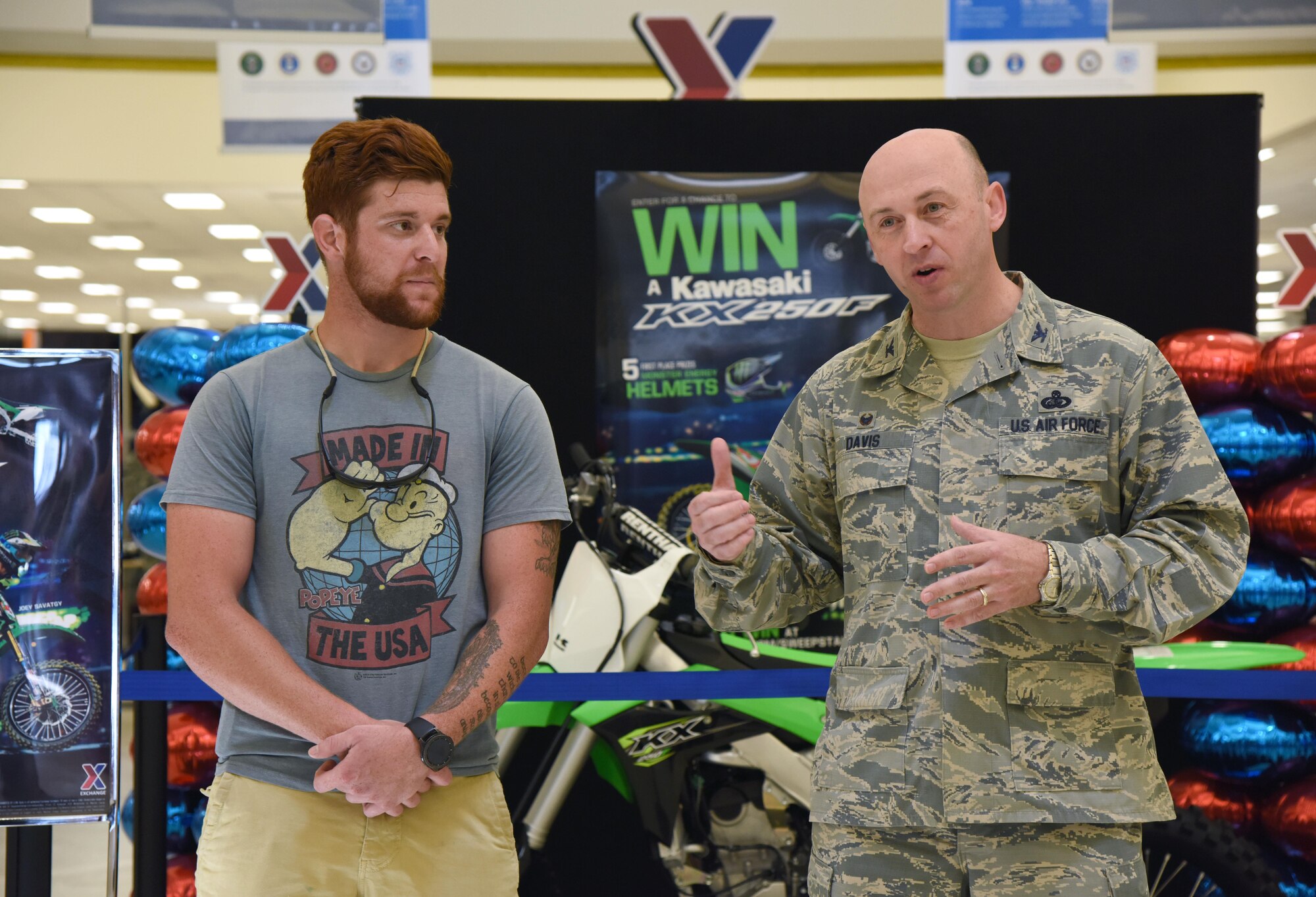 Col. Danny Davis, 81st Mission Support Group commander, delivers remarks about U.S. Army Spc. Anthony Clark, Alpha Company 1-155th infantryman, Mississippi National Guard, Biloxi, Miss., after he won a Kawasaki KXTM250F motorcycle at the Base Exchange, Aug. 19, 2017, on Keesler Air Force Base, Miss. Clark, a Biloxi native, was randomly selected from more than 16,000 entries to win the Army & Air Force Exchange Service’s Monster Kawasaki Sweepstakes, which ran from April 15 to May 31. (U.S. Air Force photo by Kemberly Groue)