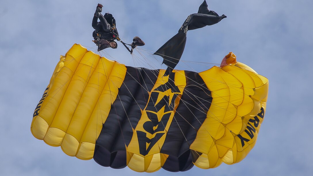 A parachutist using an Army parachute descends.