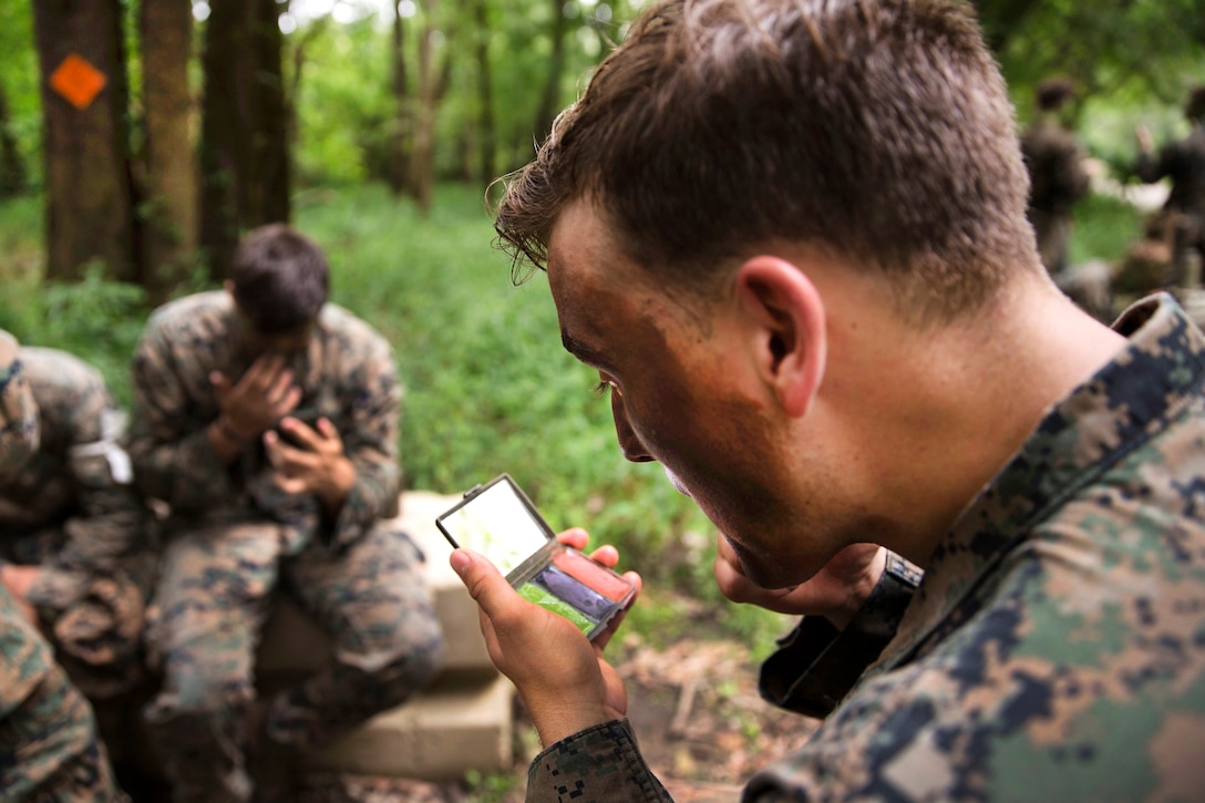 Marine applies paint to his face.