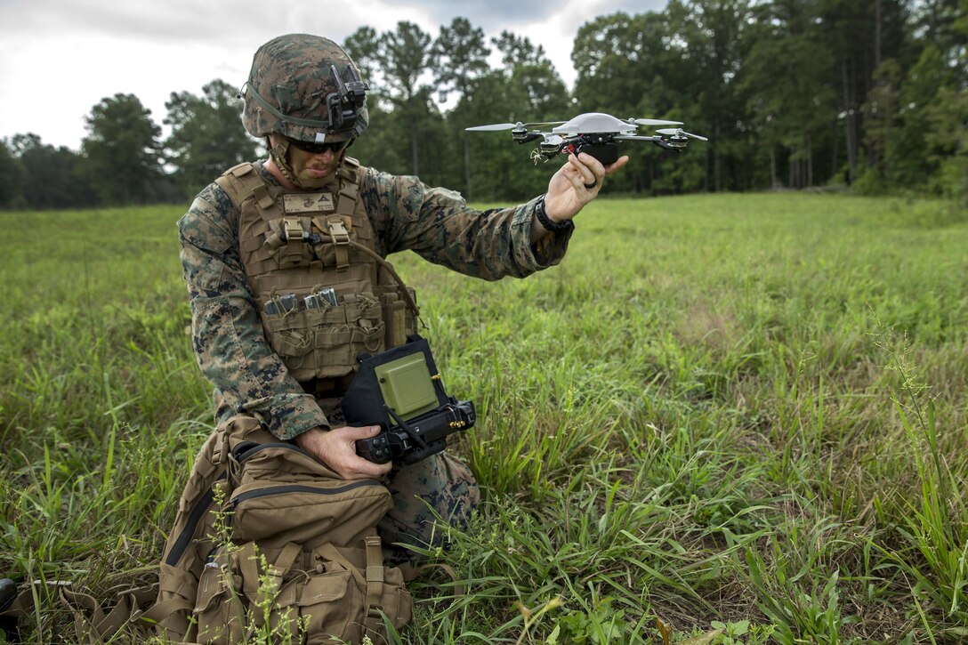 A Marine preps a surveillance device.
