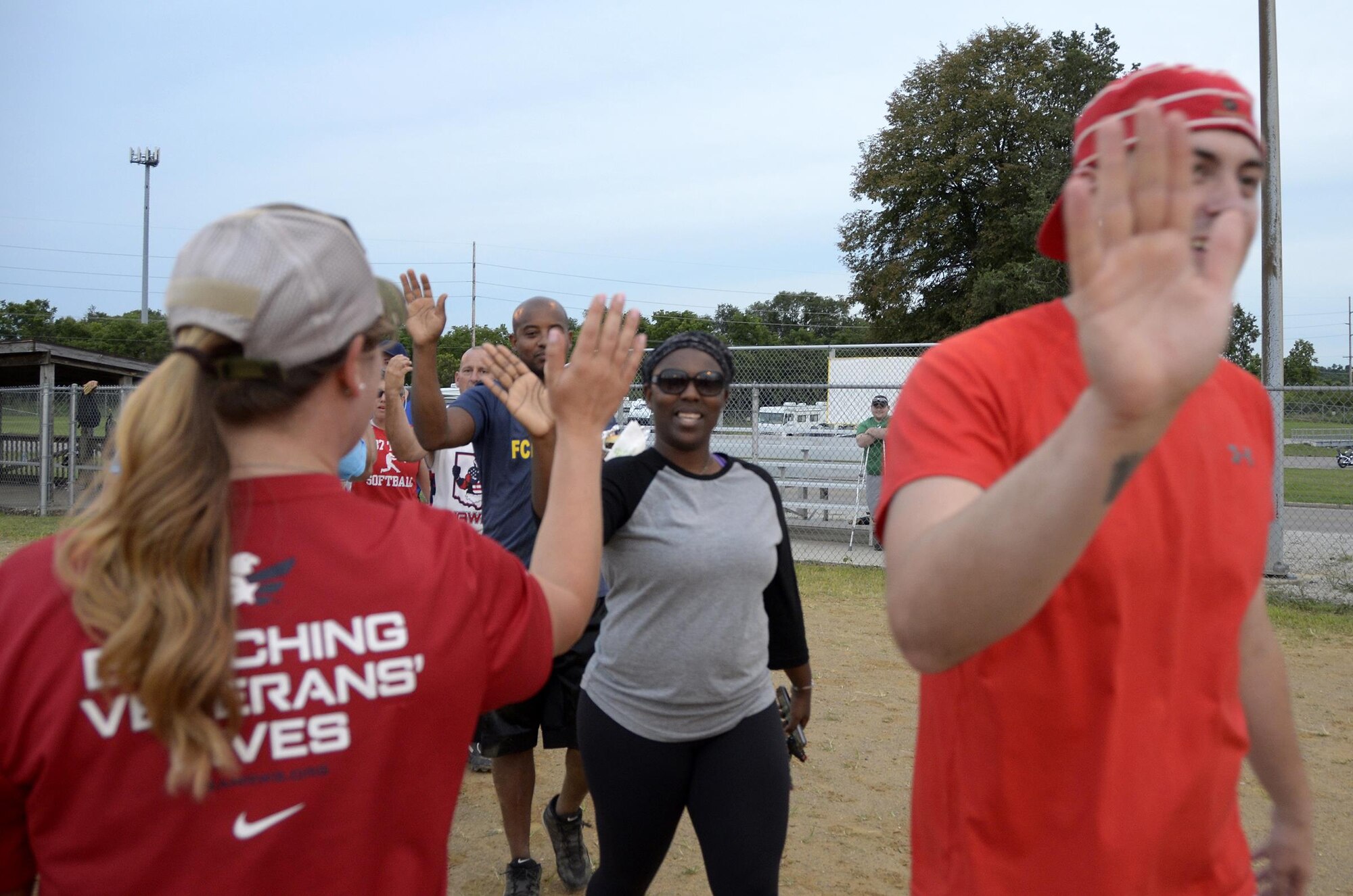 Airmen from the 445th Airlift Wing high five the active duty team after playing in the 10th Annual Sports Challenge August 5, 2017 at Dodger Field here. The competition, sponsored by the Air Force Sergeants Association Kittyhawk Chapter 751, featured an active duty team competing against a reserve team made up of Airmen from the wing. The active duty team won.  (U.S. Air Force photo/Staff Sgt. Joel McCullough)