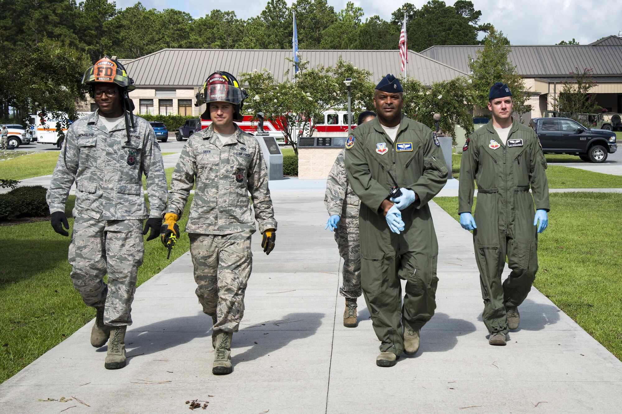 Firefighters from the 23d Civil Engineer Squadron and flight doctors from the 23d Aerospace Medical Squadron walk onto the scene during an emergency response exercise, Aug. 22, 2017, at Moody Air Force Base, Ga. The purpose of this active-shooter exercise was to inspect the recovery phase of an emergency situation while maintaining realism as members still responded as normal. (U.S. Air Force photo by Airman 1st Class Erick Requadt)