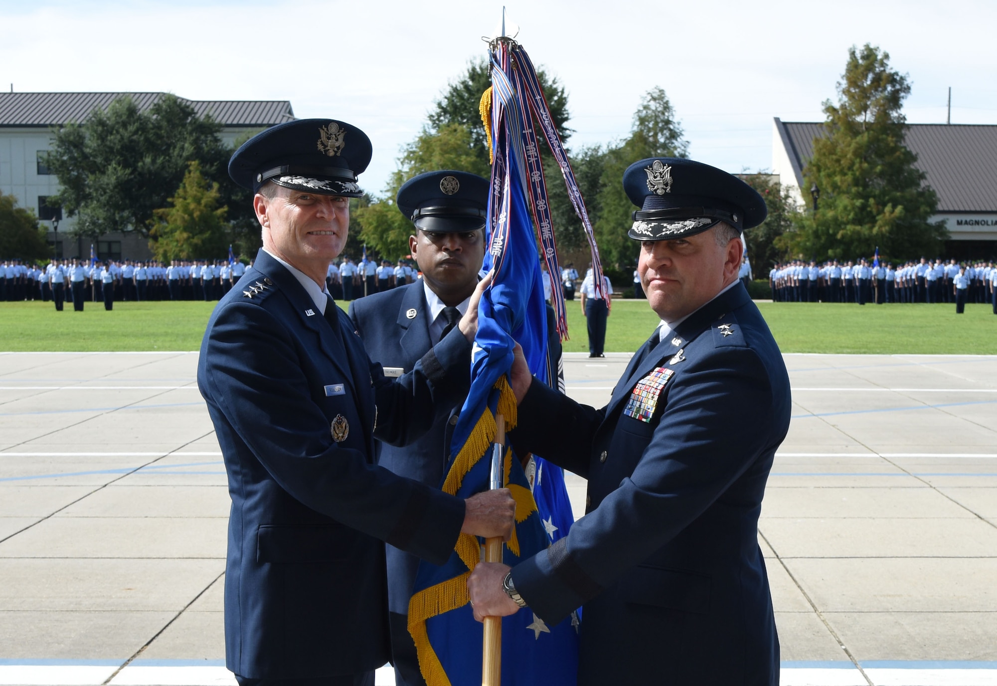 Lt. Gen. Darryl Roberson, commander of Air Education and Training Command commander, passes the 2nd Air Force guidon to Maj. Gen. Timothy Leahy, 2nd AF commander, during the 2nd AF change of command ceremony at the Levitow Training Support Facility Aug. 23, 2017, on Keesler Air Force Base, Miss. L (U.S. Air Force photo by Kemberly Groue)