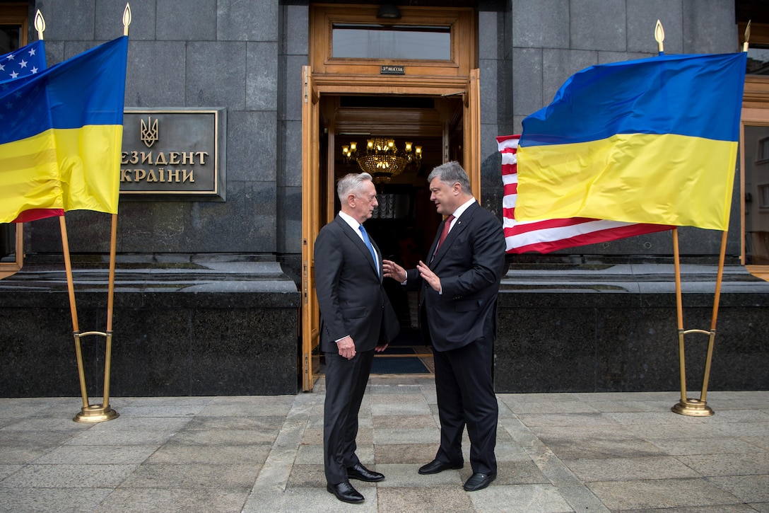 Defense Secretary Jim Mattis speaks with the Ukrainian president outside a building.