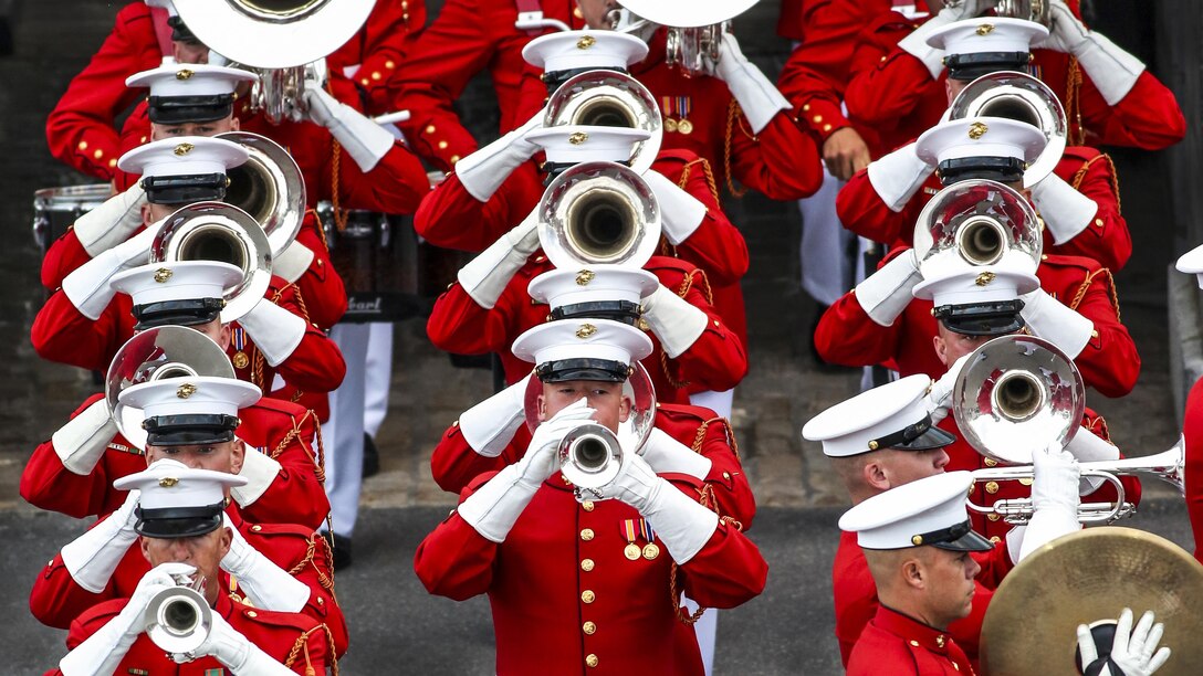 Marine Corps musicians play instruments and march in formation.