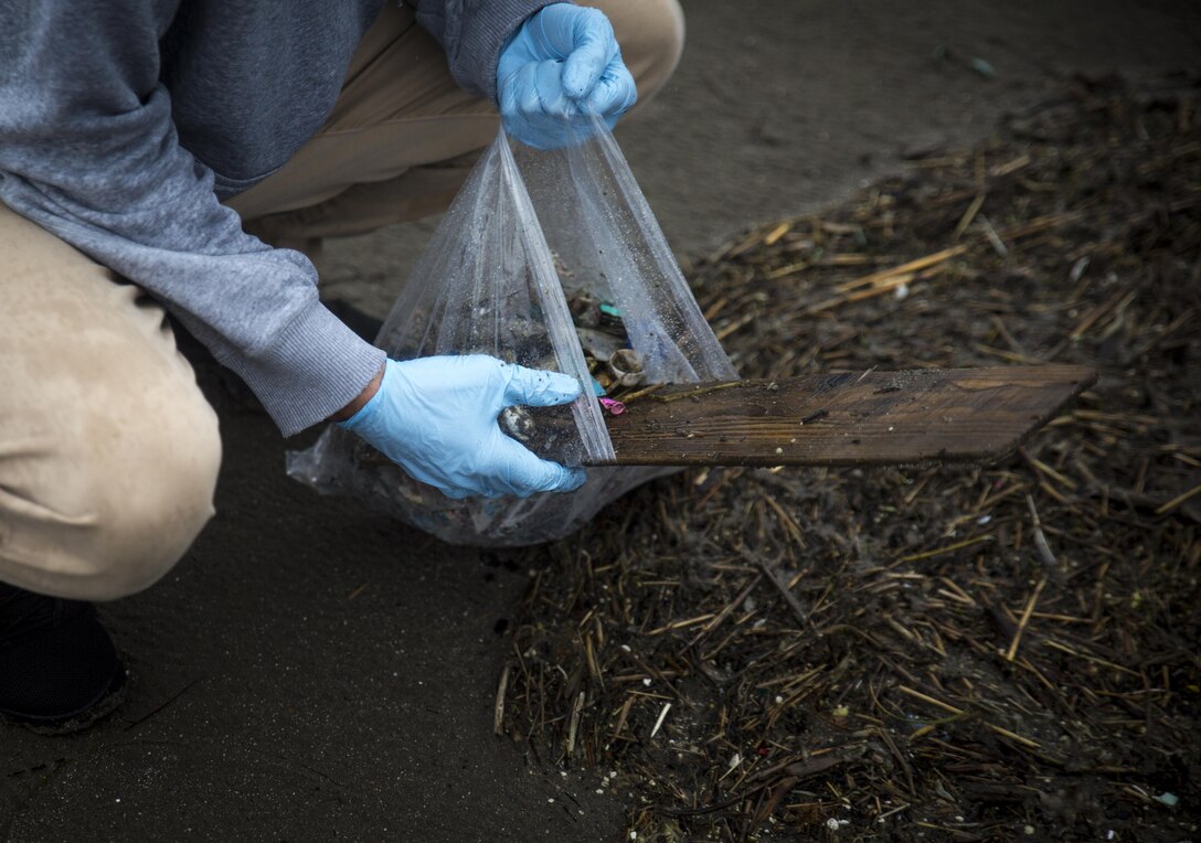 A U.S. Marine picks up trash at Miss Veedol Beach, Misawa, Japan, August 19, 2017, during Exercise Northern Viper 2017. Marines, Sailors, Airmen banded together with Misawa City employees to participate in the beach cleanup. NV17 tests the interoperability and bilateral capability of the Japan Ground Self-Defense Force and U.S. Marine Corps forces to enhance regional cooperation between participating nations to collectively deter security threats. The Marine is assigned to Marine Aircraft Group 36, 3rd Marine Aircraft Wing. (U.S. Marine Corps photo by Lance Cpl. Andy Martinez)