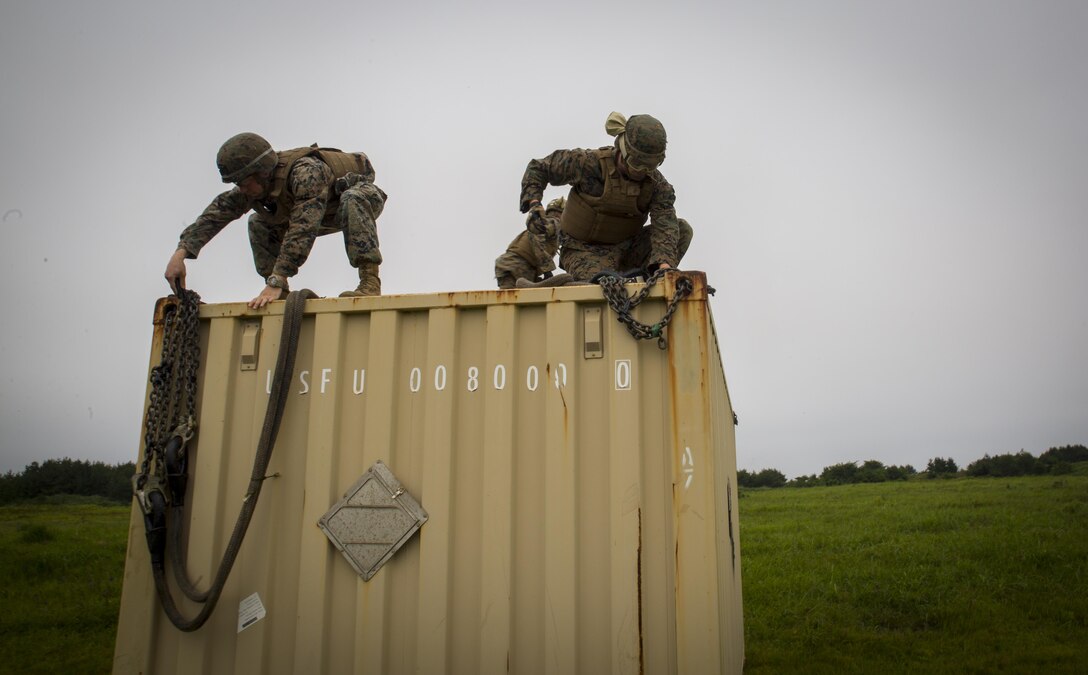Cpl. Tyler D. Reed (left) and Pfc. Tyler J. Nye (right), both landing support specialist, attach chains to a container during external lift training at Draughon Range near Misawa Air Base, Japan, August 21, 2017, in support of exercise Northern Viper 17. This combined-joint exercise is held to enhance regional cooperation between participating nations to collectively deter security threats. Reed, a Waukesha, Wisconsin native, and Nye, a Lincoln, Nebraska native, are assigned to Combat Logistics Battalion 4, Combat Logistics Regiment 3, 3rd Marine Logistic Group. (U.S. Marine Corps photo by Lance Cpl. Andy Martinez)