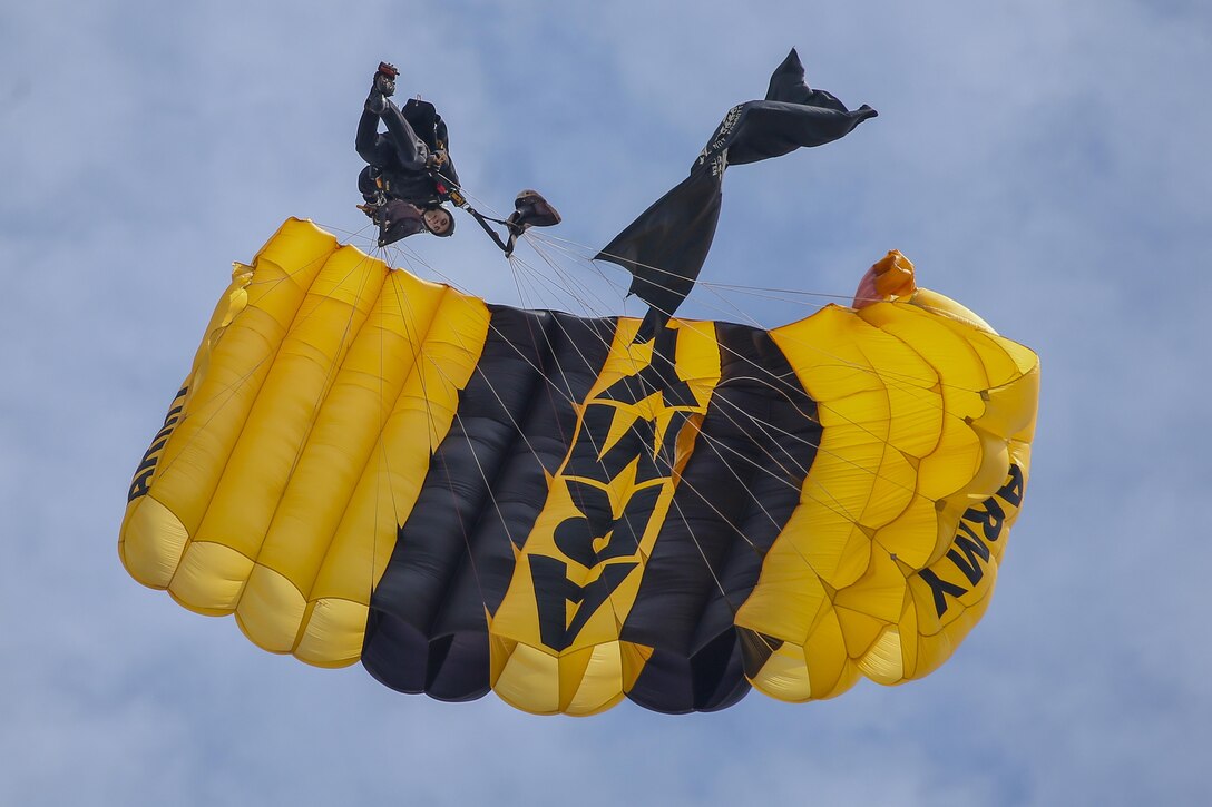 A parachutist using an Army parachute descends.