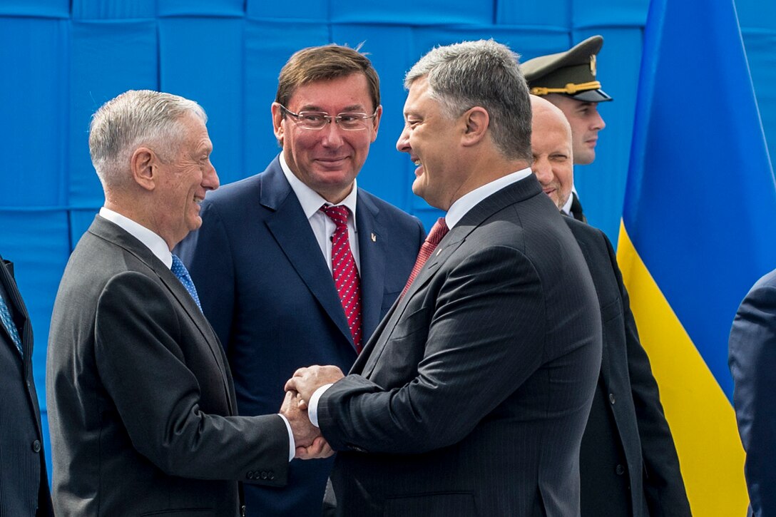 Defense Secretary Jim Mattis shakes hands with the Ukrainian president on a stage.