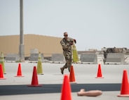U.S Air Force Tech. Sgt. Joseph Cook, non-commissioned officer of logistics with the 379th Expeditionary Civil Engineer Squadron’s Fire and Emergency Services Flight, places a cone into an exercise area during a joint C-130 Hercules aircraft exercise at Al Udeid Air Base, Qatar, Aug. 1, 2017.