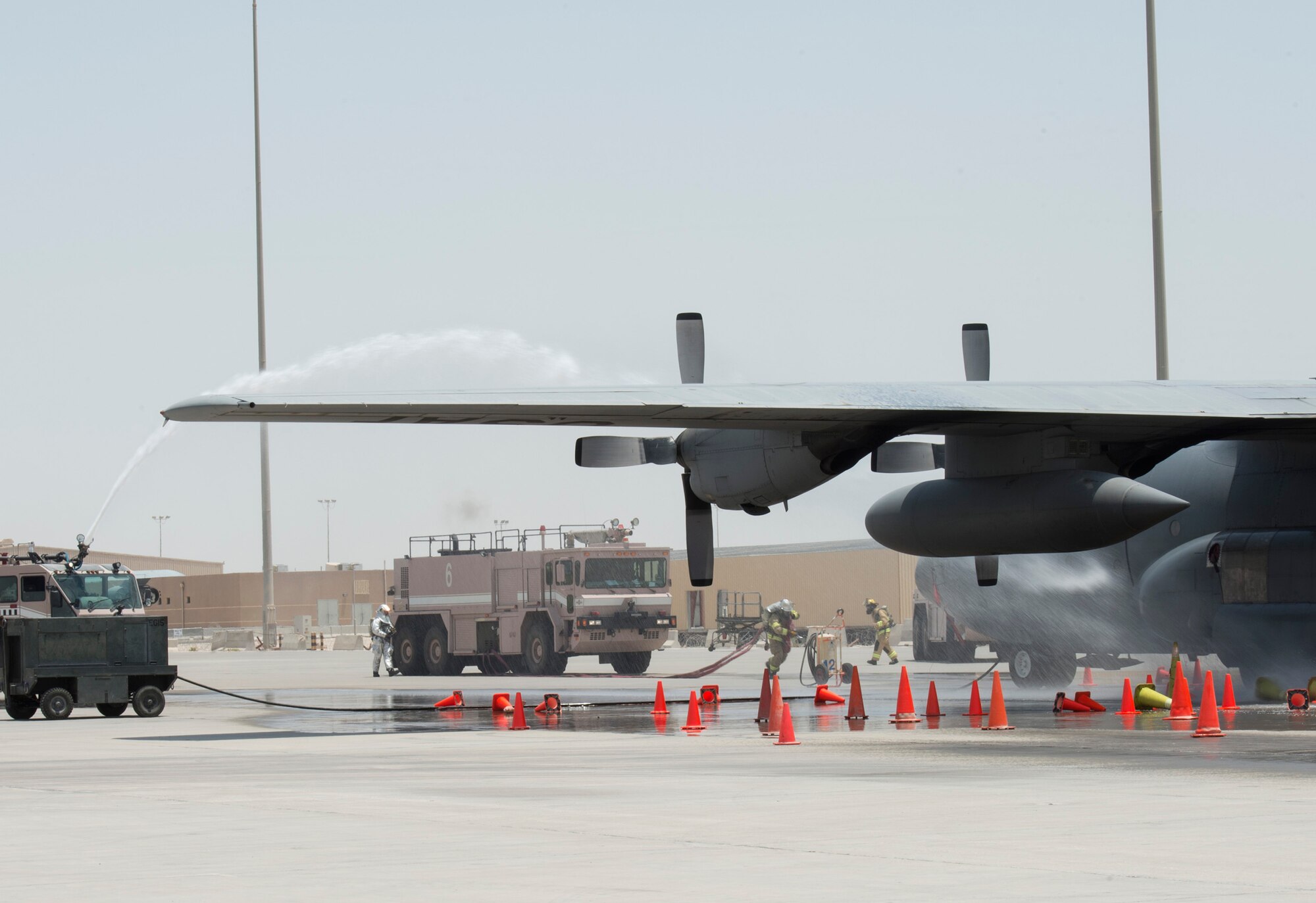 Firefighters with the 379th Expeditionary Civil Engineer Squadron’s Fire and Emergency Services Flight hose down a C-130 Hercules from Dobbins Air Force Reserve, Georgia, during a joint C-130 Hercules aircraft exercise at Al Udeid Air Base, Qatar, Aug. 1, 2017.