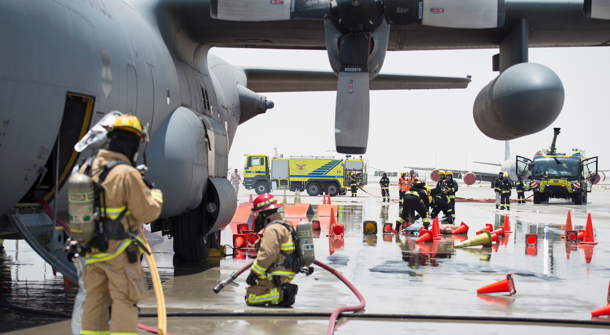 Firefighters with the 379th Expeditionary Civil Engineer Squadron’s Fire and Emergency Services Flight and the Qatar Emiri Air Force Fire Department respond to a simulated aircraft explosion during a joint C-130 Hercules aircraft exercise at Al Udeid Air Base, Qatar, Aug. 1, 2017.