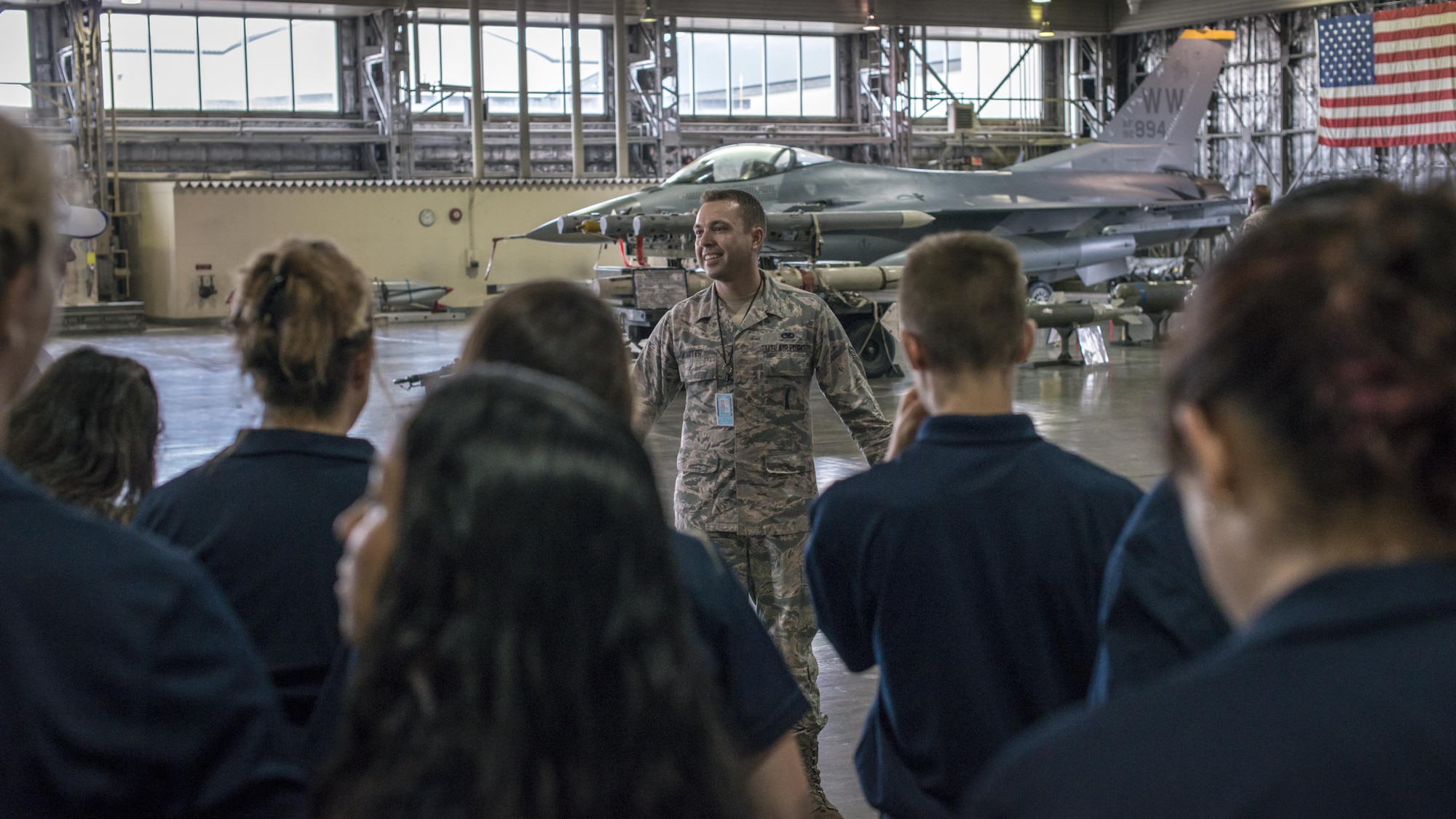 U.S. Air Force Senior Airman Robert Carter, a 35th Maintenance Group weapons lead crew member, talks with a group of delegates from Wenatchee Valley, Washington, during their base familiarization tour at Misawa Air Base, Japan, Aug. 24, 2017.